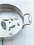 Fresh sage leaves and garlic in a frying pan with a little oil