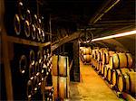 Wooden wine barrels and bottles in a cellar