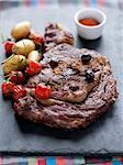 Grilled beef entrecôte with olives,cherry tomatoes and Ratte potatoes