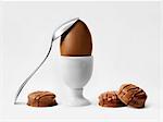 Chocolate egg in an eggcup and bite-size chocolates