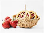 Strawberry jam cookies in a basket and fresh strawberries