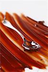 Spreading the melted chocolate onto a marble surface with the back of a spoon