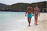 Couple Holding Hands and Walking on Beach, Sardinia, Italy