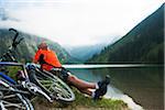 Mature Man Sitting by Lake with Mountain Bike, Vilsalpsee, Tannheim Valley, Tyrol, Austria