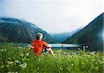 Mature Man with Mountain Bike sitting by Lake, Vilsalpsee, Tannheim Valley, Tyrol, Austria