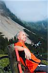 Mature Man on Bench by Lake with Mountain Bike, Vilsalpsee, Tannheim Valley, Tyrol, Austria