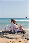 Couple Leaning against each other at Beach, Sardinia, Italy