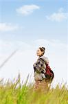 Young girl with camera on grassland smiling away