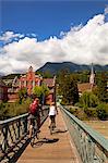 Austria, Tyrol, Innsbruck. The wooden and metal walking bridge with cyclists crossing