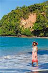 Dominica, Calibishie. A young woman walks along Batibou Beach. (MR).