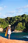 Dominica, Calibishie. A young woman looks out from the red rocks at Pointe Baptiste. (MR).