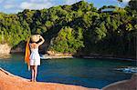 Dominica, Calibishie. A young woman looks out from the red rocks at Pointe Baptiste. (MR).