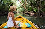 Dominica, Portsmouth. A young woman sits on a boat on the Indian River, one of Dominica's most popular tourist attractions. (MR).