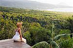 Dominica, Portsmouth, Tanetane. A young lady admires the view towards Portsmouth from Manicou River Resort.(MR).