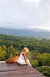 Dominica, Portsmouth, Tanetane. A young lady admires the view towards Portsmouth from Manicou River Resort.(MR).