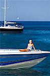 Dominica, Roseau. A young woman sits on the foredeck of a Powerboat near Roseau. (MR).