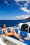 Dominica, Soufriere. A young woman sunbathes on the back of a Powerboat near Soufriere. (MR).