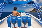 Dominica, Soufriere. A young woman at the helm of a  Powerboat near Soufriere. (MR).