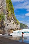 Dominica, Riviere Cyrique. A young woman stands looking at the waterfall at Wavine Cyrique. (MR).