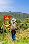 Dominica, Riviere Cyrique. A young woman stands by a sign at the start of the trail to Wavine Cyrique. (MR).