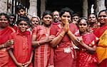 India, Tamil Nadu, Madurai, Sri Meenakshi Temple. Ladies dressed in colourful red saris join other pilgrims to worship at the Meenakshi Temple.