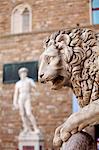 Italy, Tuscany, Florence. Sculptures in Piazza della Signoria with a copy of the famous David by Michelangelo in the background