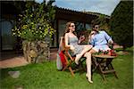 Couple Relaxing and having Drinks Outdoors at Hotel, Sardinia, Italy