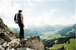 Mature woman standing on cliff, hiking in mountains, Tannheim Valley, Austria