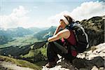 Mature woman sitting on cliff, hiking in mountains, Tannheim Valley, Austria