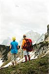 Backview of mature couple hiking in mountains, Tannheim Valley, Austria