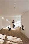 Woman standing by wall in empty room