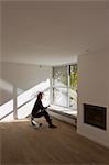 Woman sitting on chair in empty room