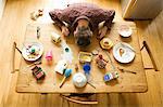 Overhead view of breakfast table with mature man amongst messy plates