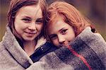 Portrait of girls wrapped in a blanket outdoors