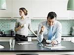 Mature businessman using tablet over breakfast in kitchen