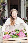 Portrait of teenage girl carrying crate of flowers