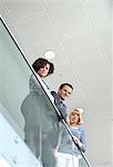 Portrait of three colleagues leaning on railing, low angle