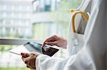 Close up of young male doctor using digital tablet