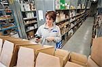 Female warehouse worker checking orders