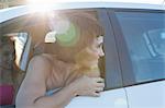 Woman looking over shoulder through car window