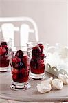 Mixed berries in glasses with meringues