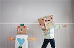 Boy with box covering head and homemade toy robot