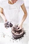 Woman sprinkling chocolate chips on cake