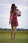 Young woman on grass, rear view, oudoors