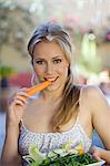 Portrait of a young woman eating carrot