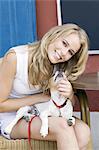 Young woman sitting at coffee shop terrace with a little dog