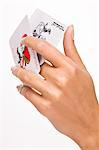 Woman's hand holding two playing cards (joker)