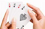 Woman's hand holding four playing cards (ace)