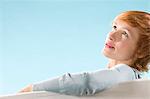 Portrait of woman on light blue background looking up