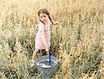 Little girl playing with a bucket of water